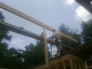 Carpenter setting a ridge beam over a new addition frame — Ice Dam Removal by Roofing Brothers in Anamosa