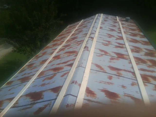 Rusted metal roof panels with new wood purlins before replacement — Storm Damage Roof Repair in Anamosa by Roofing Brothers