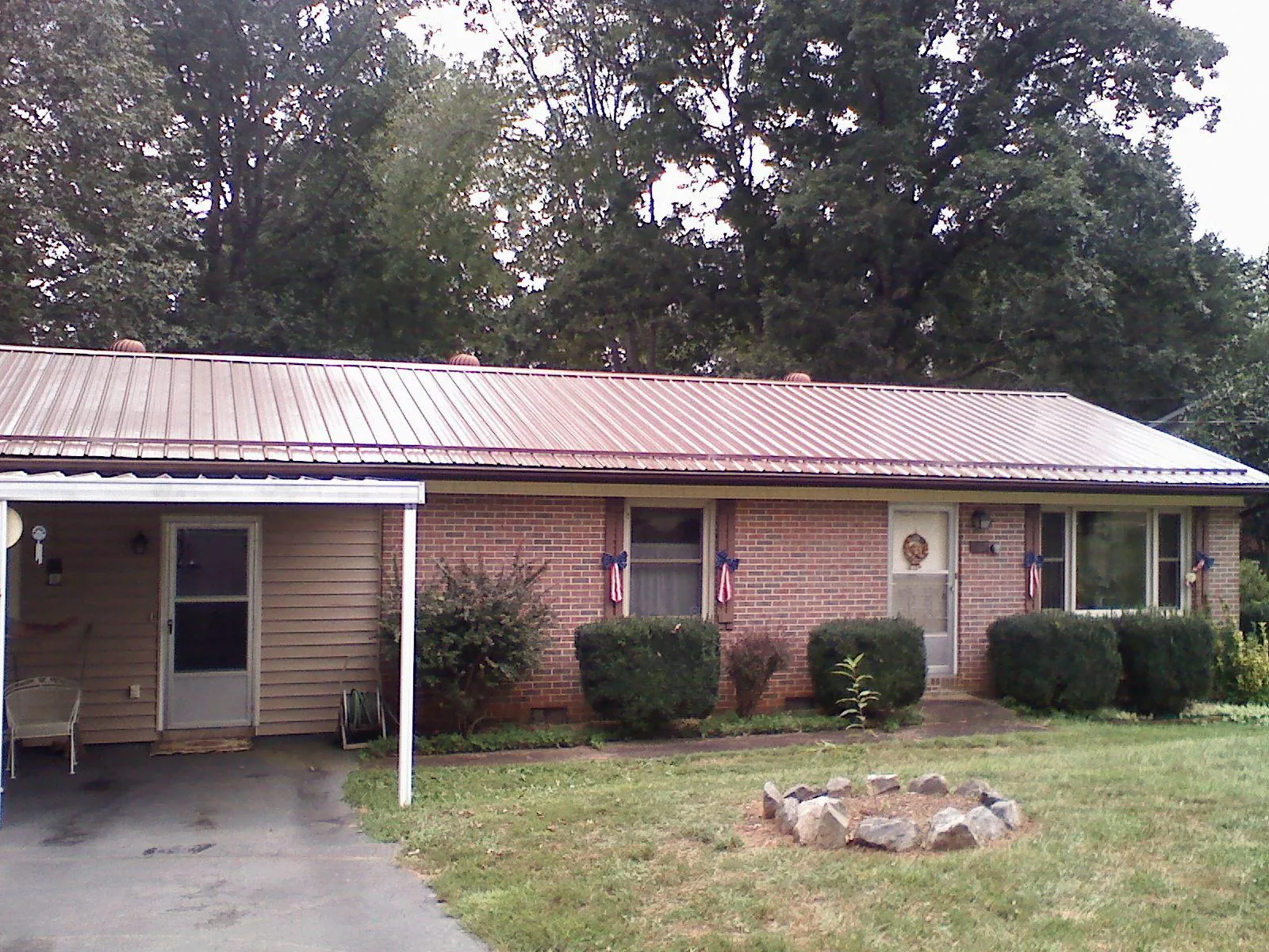 Bronze metal roof and carport on a brick ranch home — Roof Repair work by our crew in Anamosa